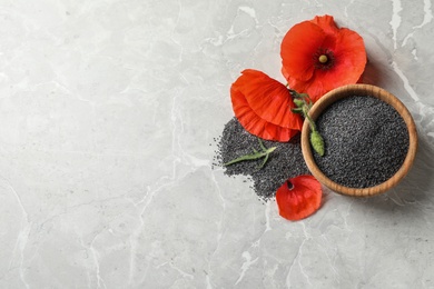 Photo of Wooden bowl of poppy seeds and flower on grey table, flat lay with space for text