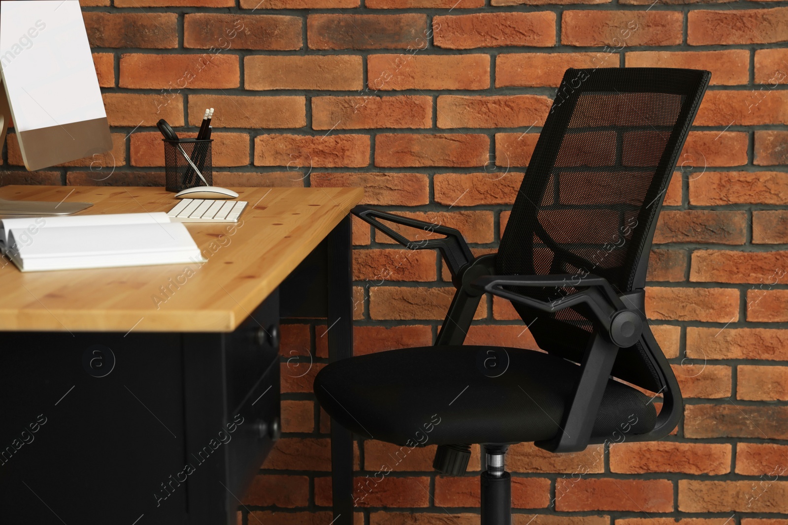 Photo of Comfortable office chair near desk at workplace