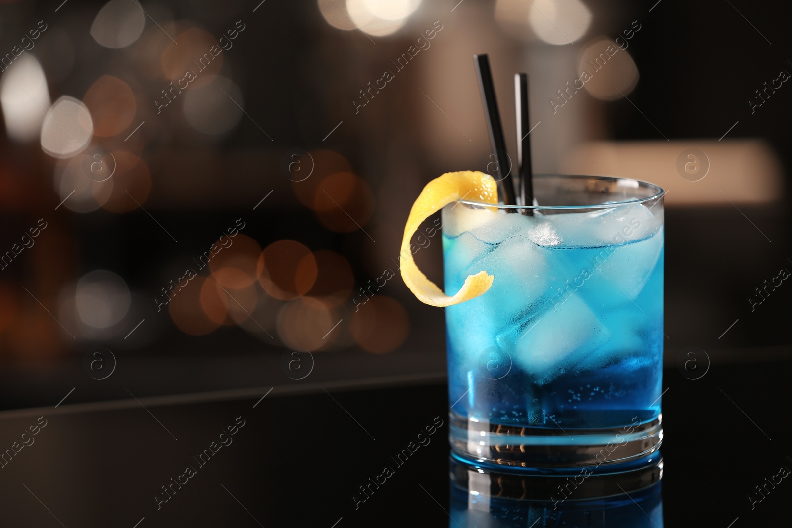 Photo of Glass of fresh alcoholic cocktail on bar counter, space for text