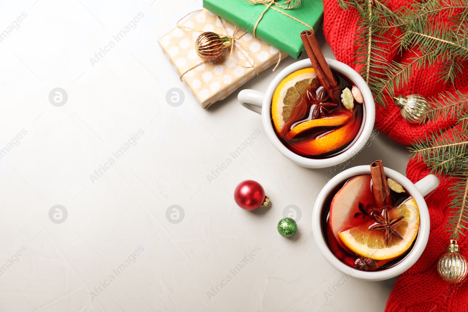 Photo of Cups of tasty mulled wine on grey background, flat lay. Space for text