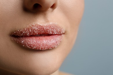 Photo of Closeup view of woman with lips covered in sugar on light grey background