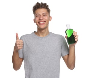 Photo of Young man with mouthwash showing thumbs up on white background