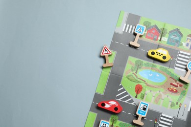 Photo of Set of wooden road signs and cars on light grey background, flat lay with space for text. Children's toy