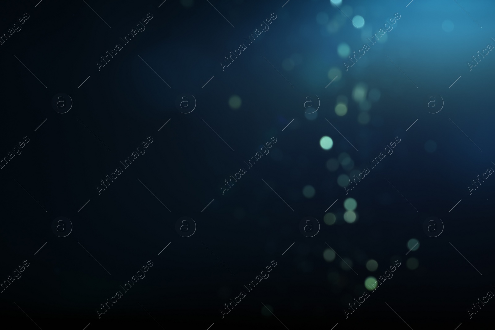 Photo of Blurred view of festive lights on blue background. Bokeh effect