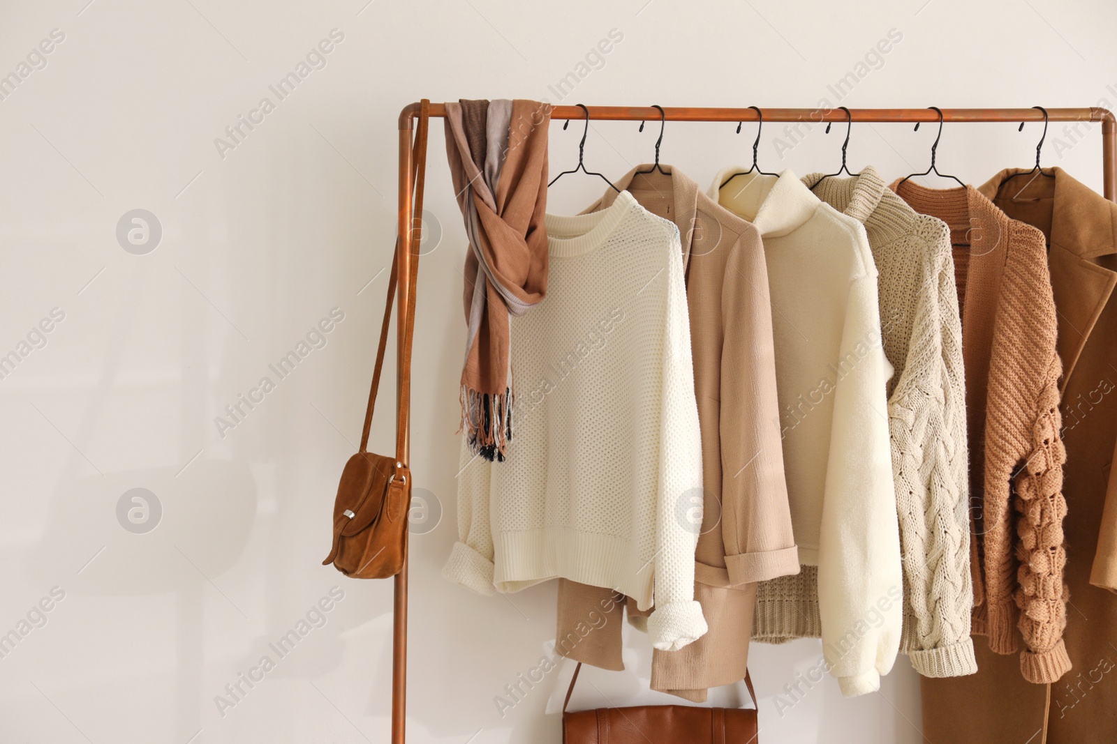 Photo of Rack with stylish women's clothes indoors. Modern interior design