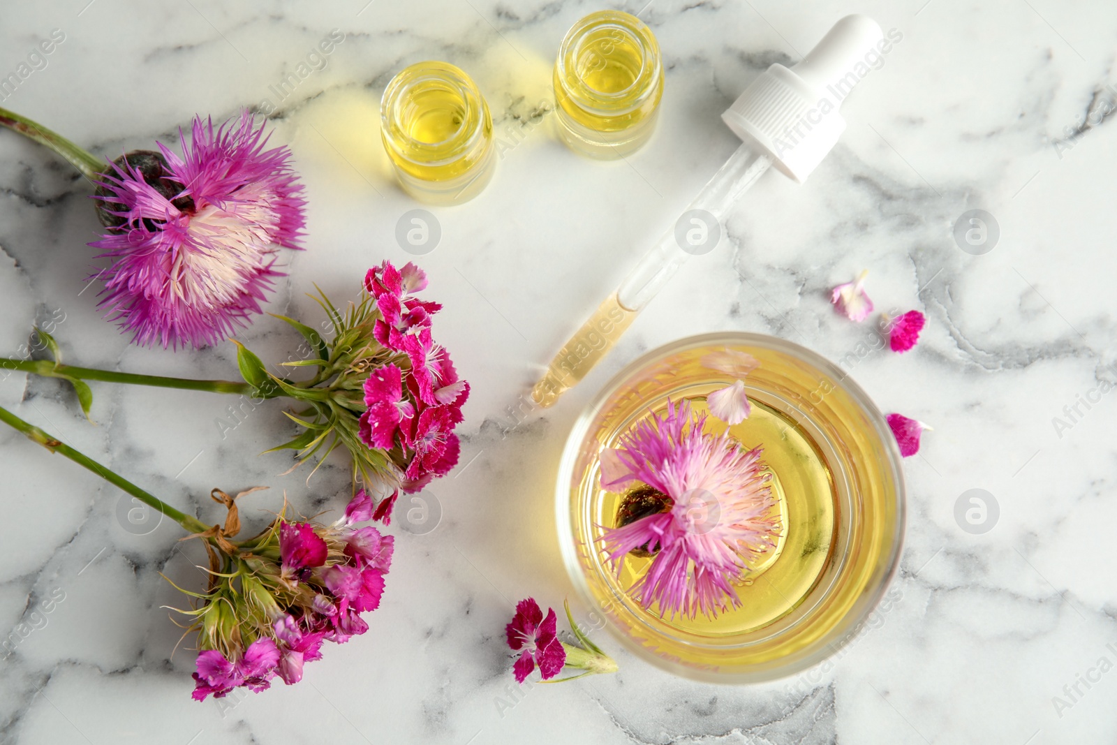 Photo of Flat lay composition with essential oils and flowers on marble background