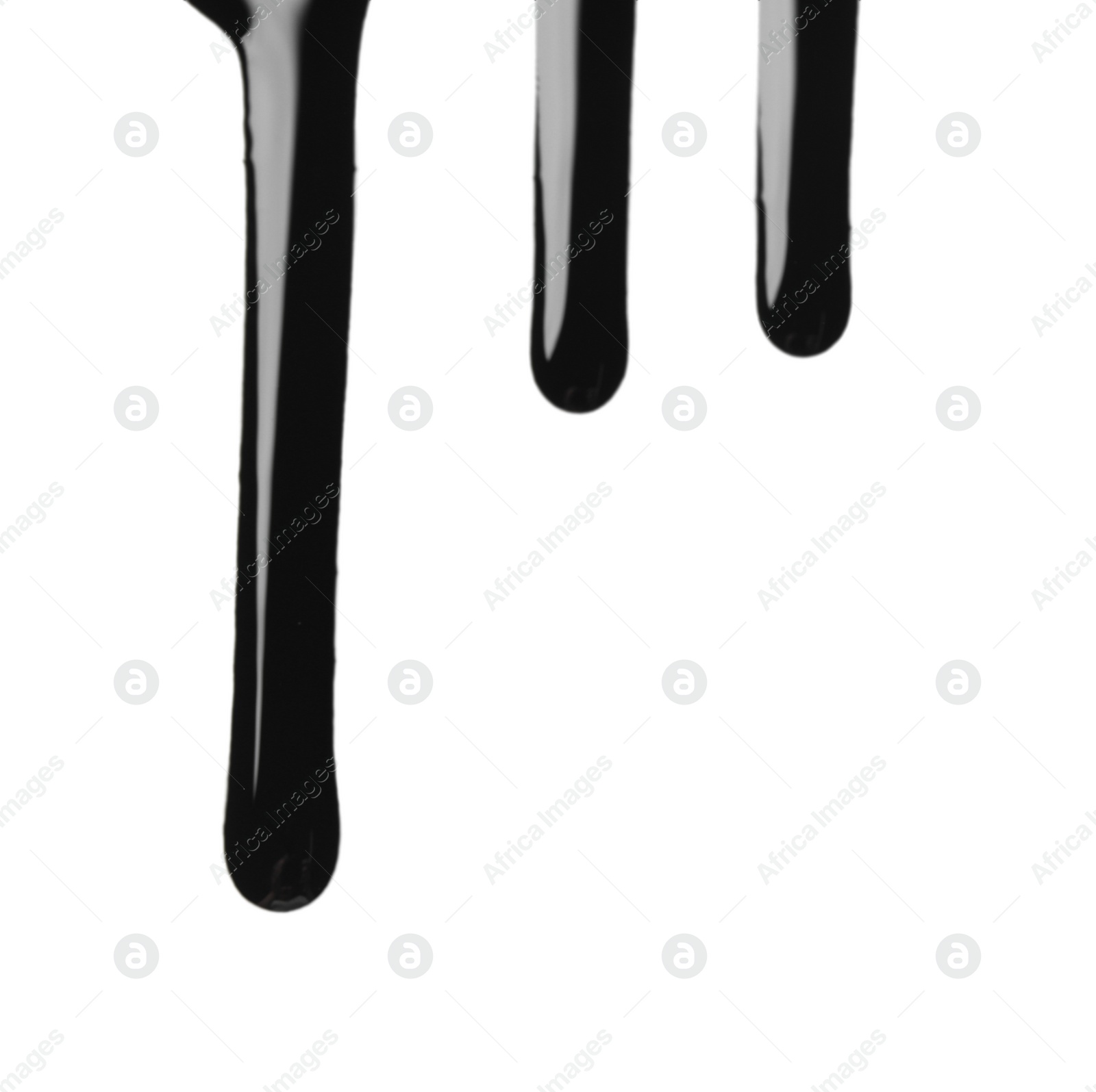 Photo of Black glossy oil flowing on white background