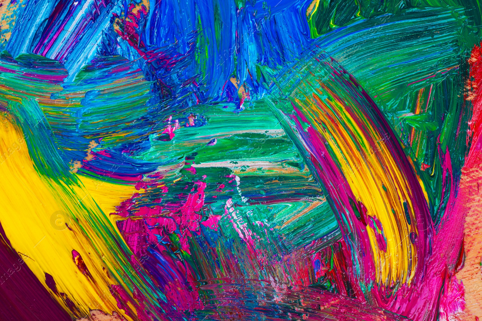 Photo of Closeup view of artist's palette with mixed bright paints as background