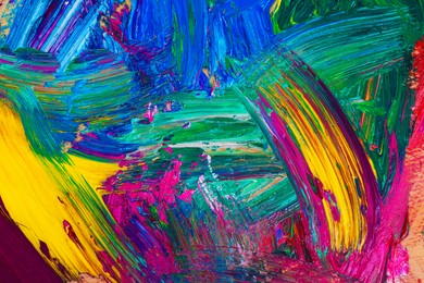 Closeup view of artist's palette with mixed bright paints as background