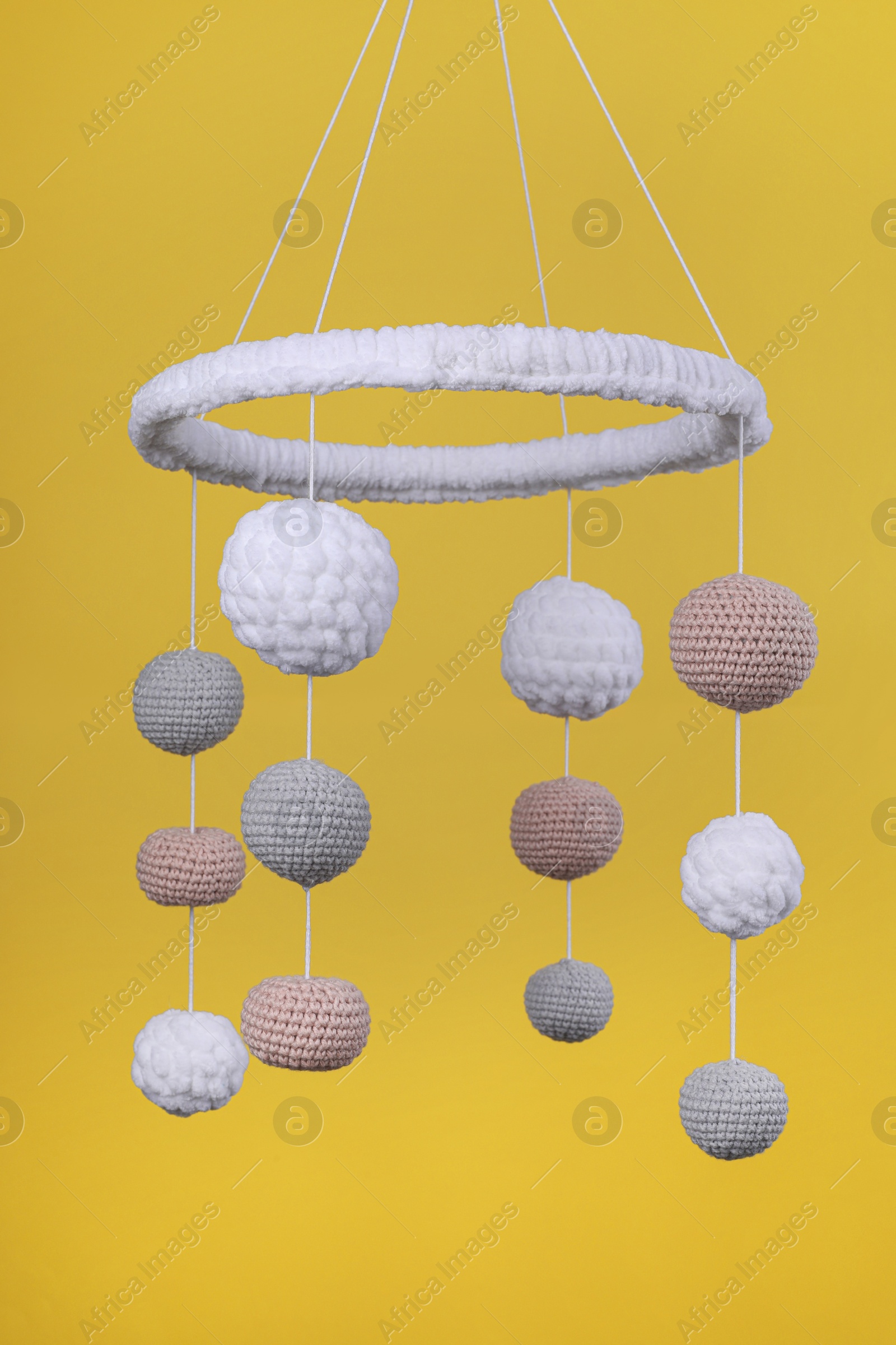 Photo of Cute baby crib mobile on yellow background