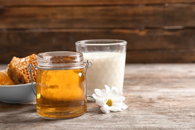 Beautiful composition with milk and honey on wooden table