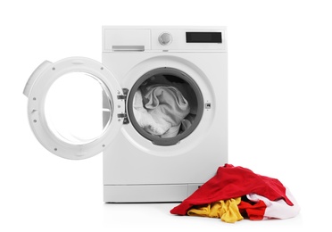 Modern washing machine with laundry on white background