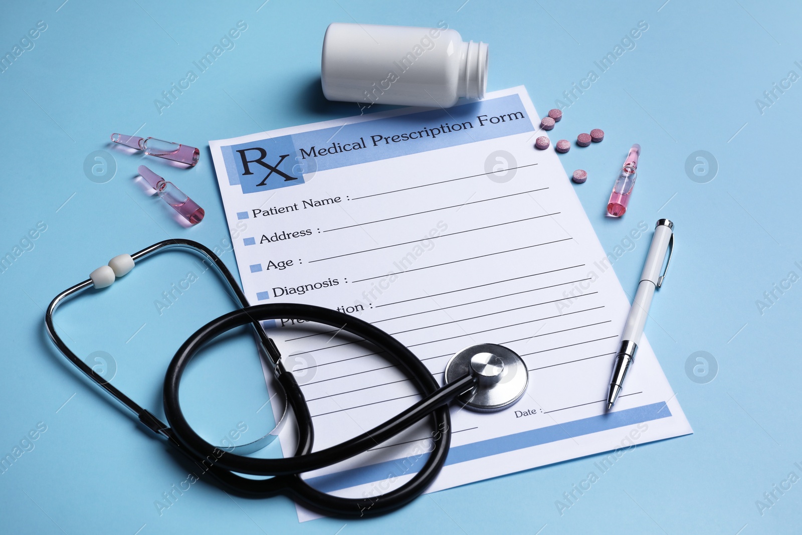 Photo of Medical prescription form, stethoscope, ampoules and pills on light blue background