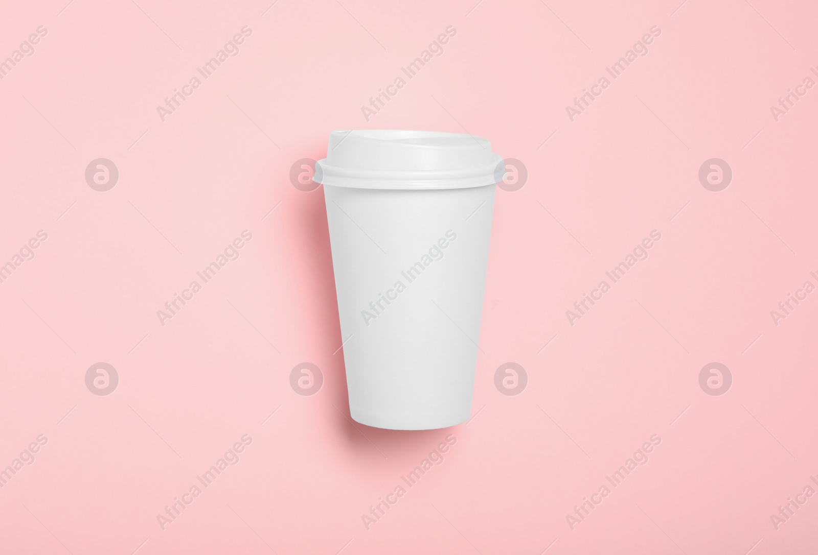 Photo of Takeaway paper coffee cup on pink background, top view