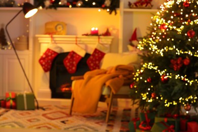 Blurred view of living room interior with fireplace, armchair and Christmas decor