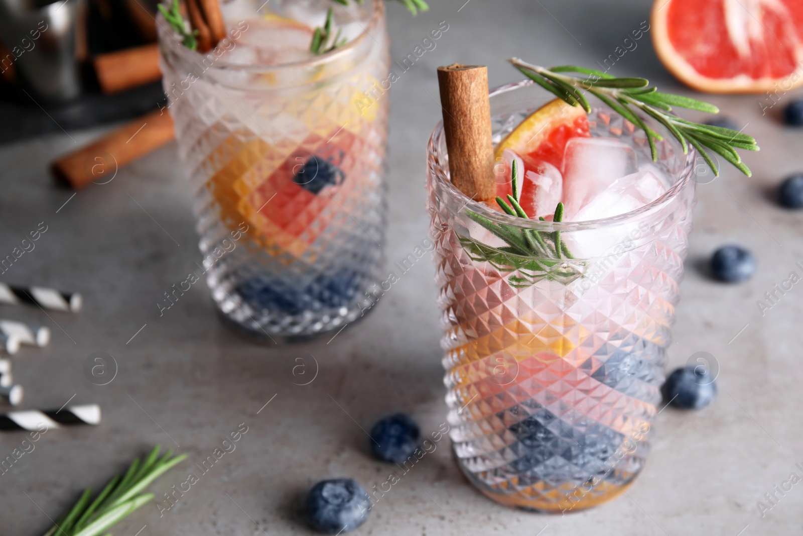 Photo of Tasty refreshing grapefruit cocktail with rosemary on table