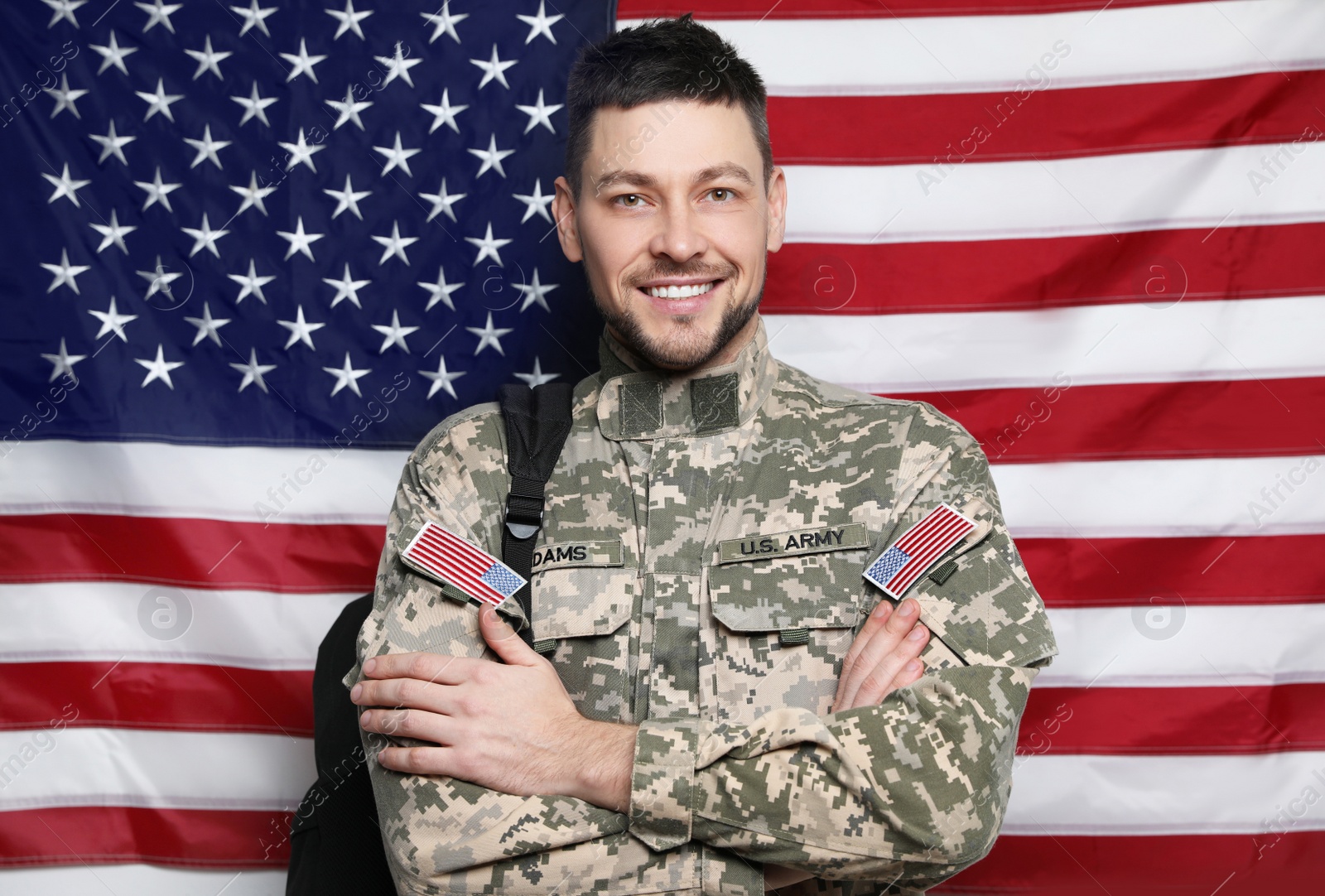 Photo of Cadet with backpack against American flag. Military education