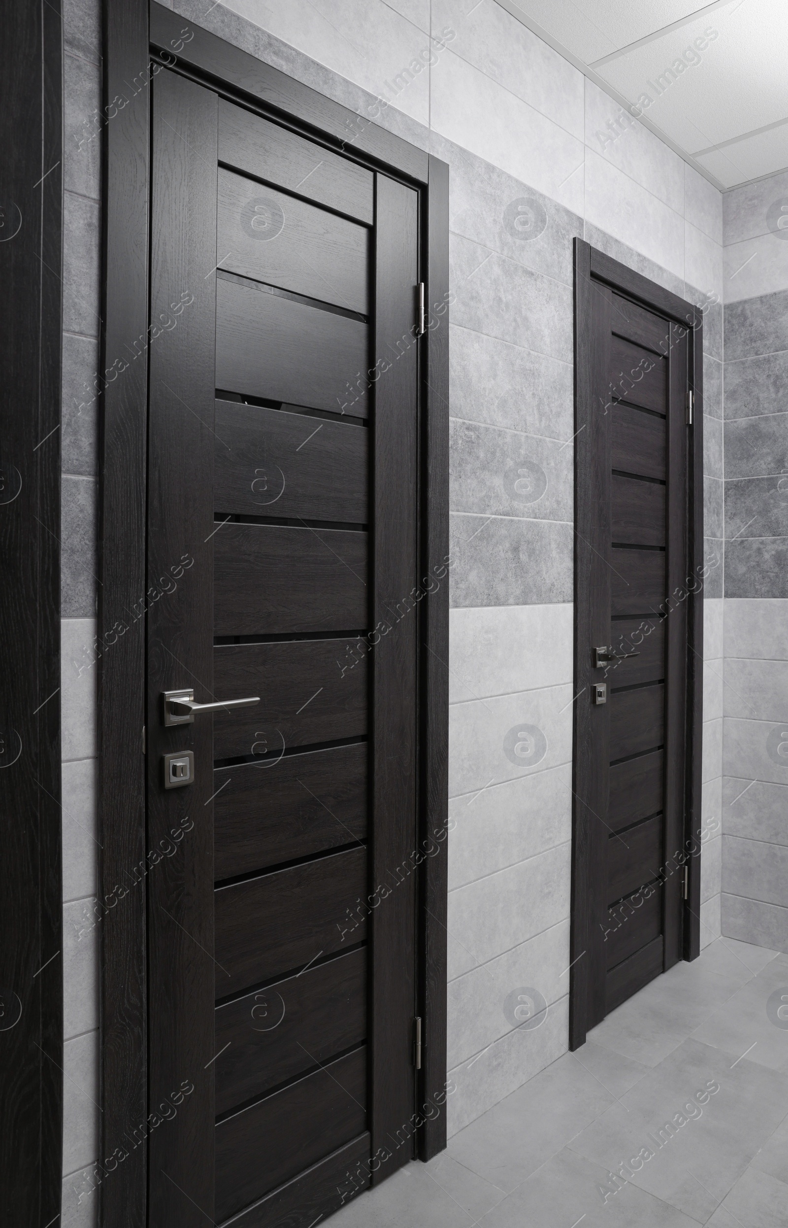 Photo of Public toilet interior with stylish doors and tiles