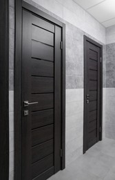 Photo of Public toilet interior with stylish doors and tiles