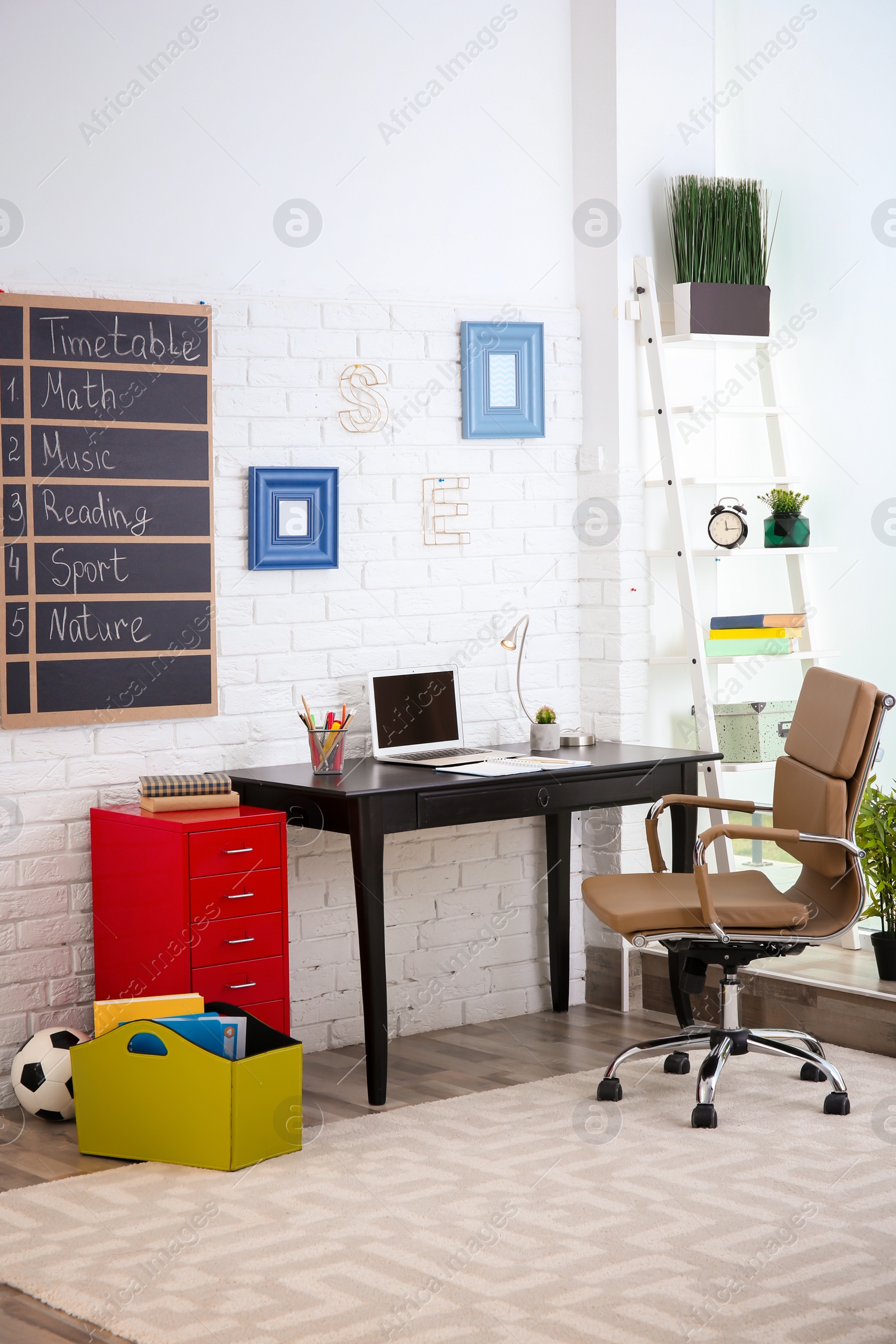 Photo of Modern child room interior with desk and laptop