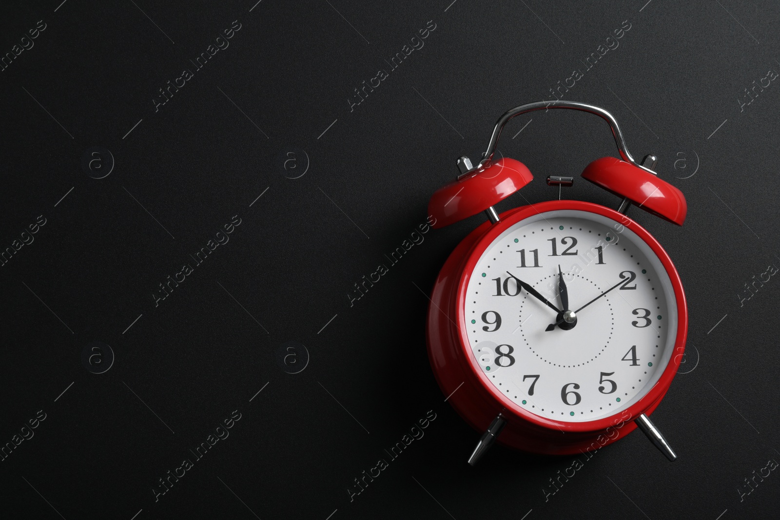 Photo of Alarm clock and space for text on black background, above view. School time