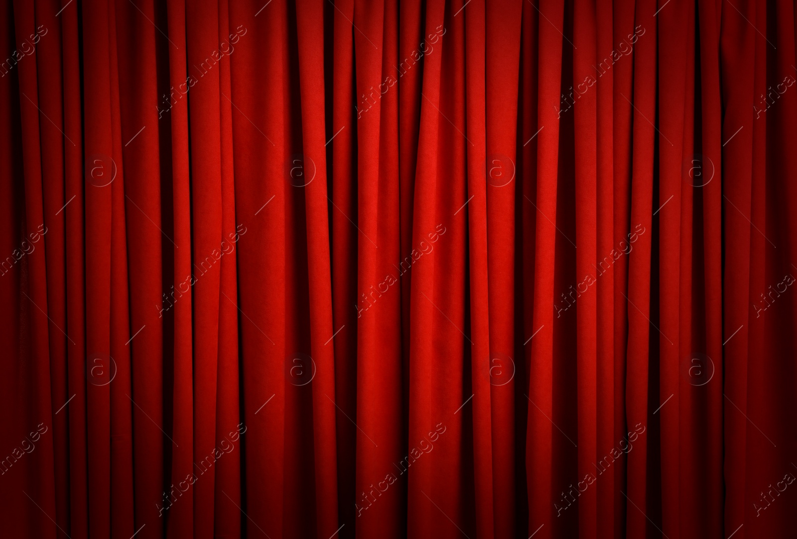 Image of Spotlight illuminating closed red stage curtains. Start of performance 