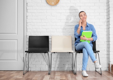 Photo of Young woman waiting for job interview, indoors