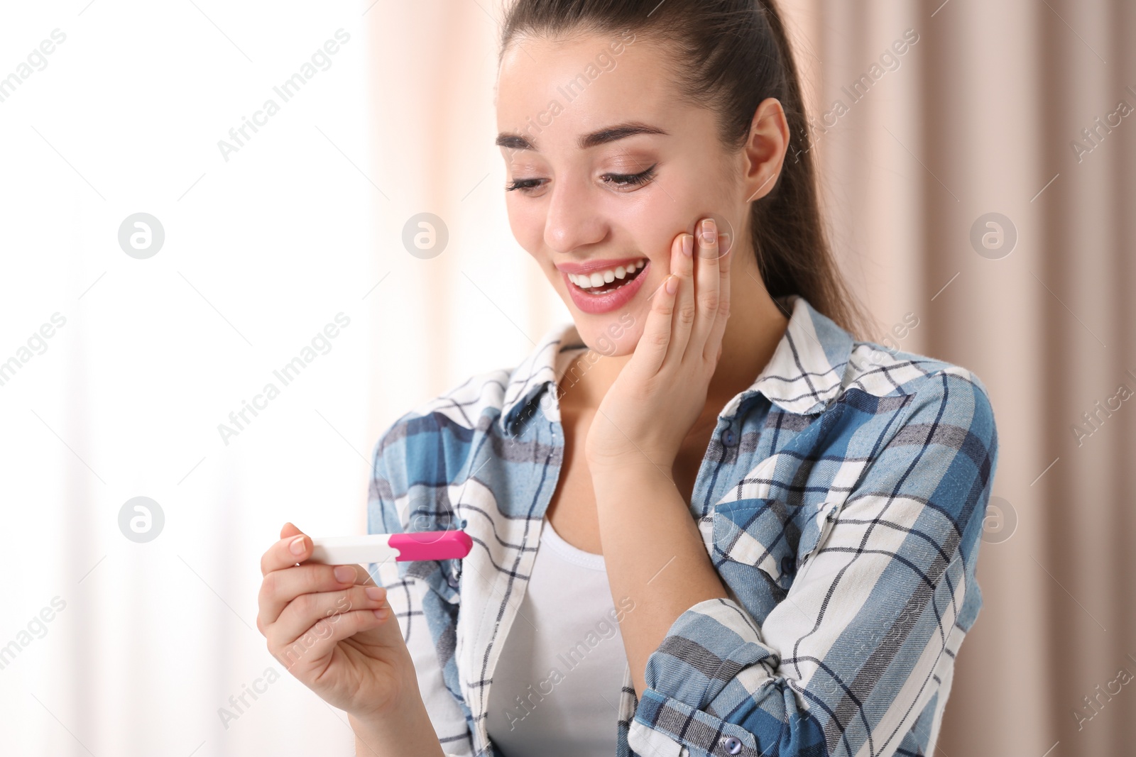 Photo of Young woman with pregnancy test at home. Gynecology and childbirth