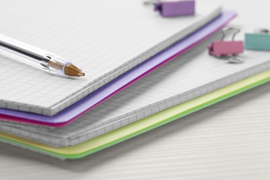 Photo of Ballpoint pen and notebooks on wooden table, closeup