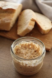 Photo of Sourdough starter in glass jar on wooden table