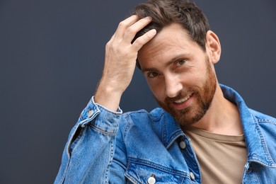 Portrait of smiling handsome bearded man on grey background. Space for text