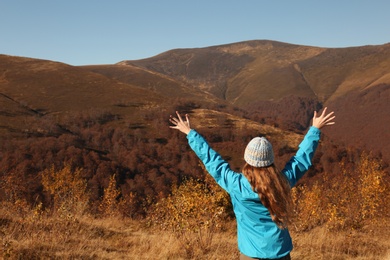 Woman in warm clothes enjoying mountain landscape