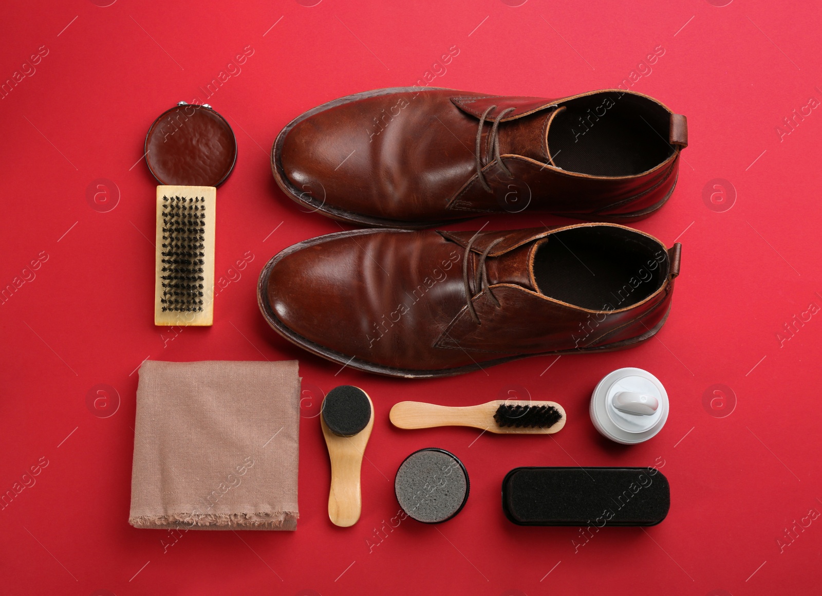 Photo of Flat lay composition with shoe care accessories and footwear on red background