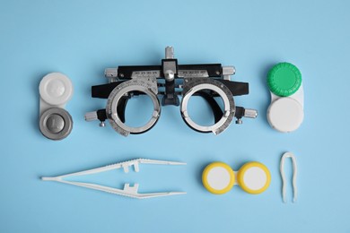 Different ophthalmologist tools on light blue background, flat lay