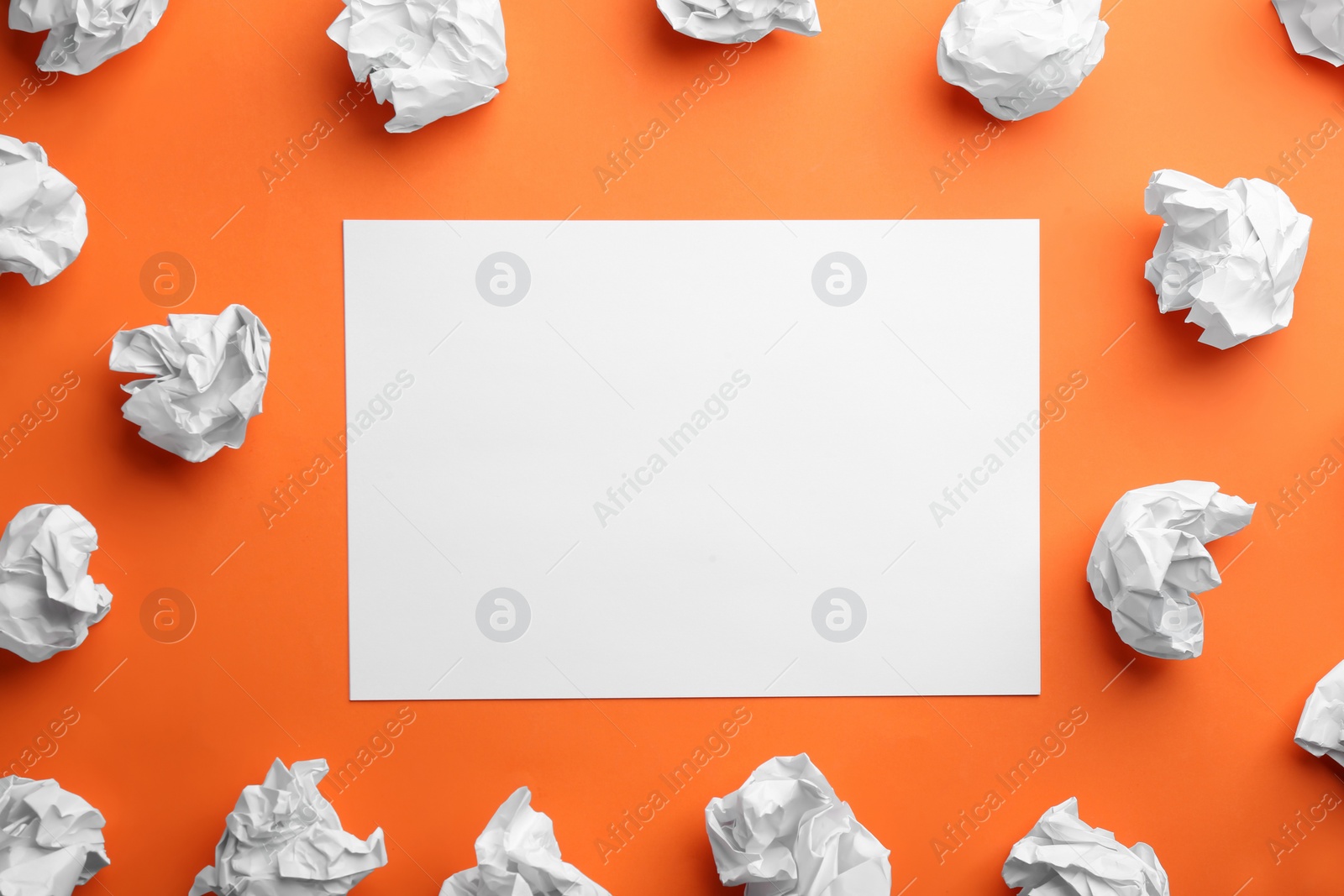 Photo of Blank sheet and crumpled paper balls on orange background, flat lay. Space for text