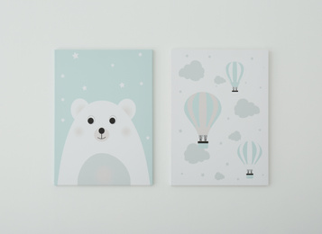 Photo of Adorable pictures of bear and air balloons on white wall. Children's room interior elements