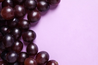 Fresh ripe juicy grapes on pink background, flat lay. Space for text