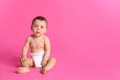 Cute baby in dry soft diaper sitting on pink background. Space for text