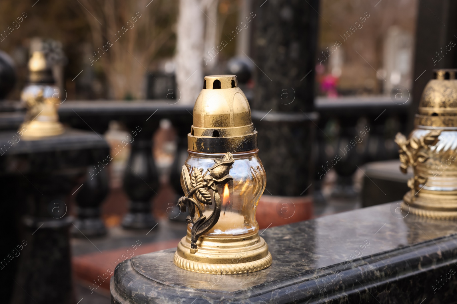 Photo of Grave lanterns on granite surface at cemetery