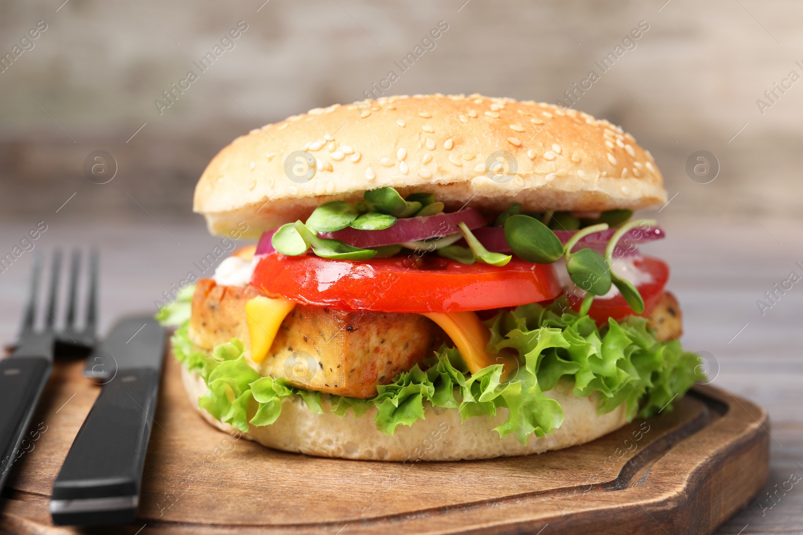 Photo of Delicious burger with tofu and fresh vegetables served on table, closeup