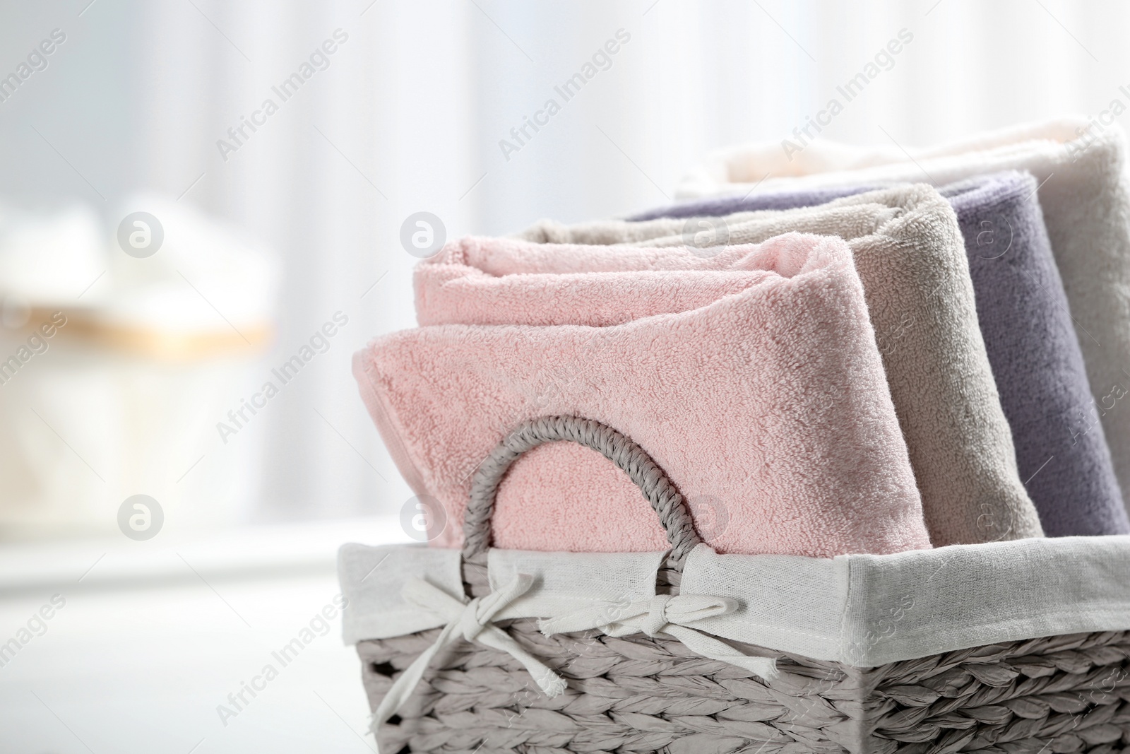 Photo of Basket of fresh towels, closeup. Space for text