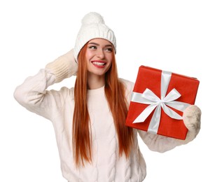 Young woman in hat and sweater with Christmas gift on white background