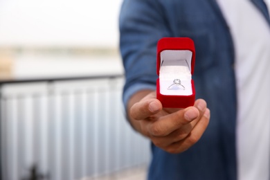 Photo of Man with engagement ring outdoors, closeup view