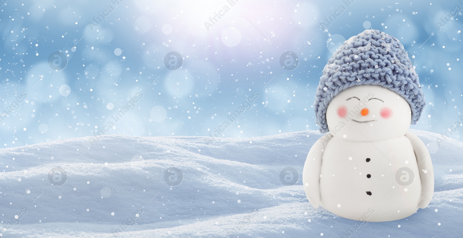 Image of Cute decorative snowman in blue hat outdoors on snowy day, space for text. Banner design