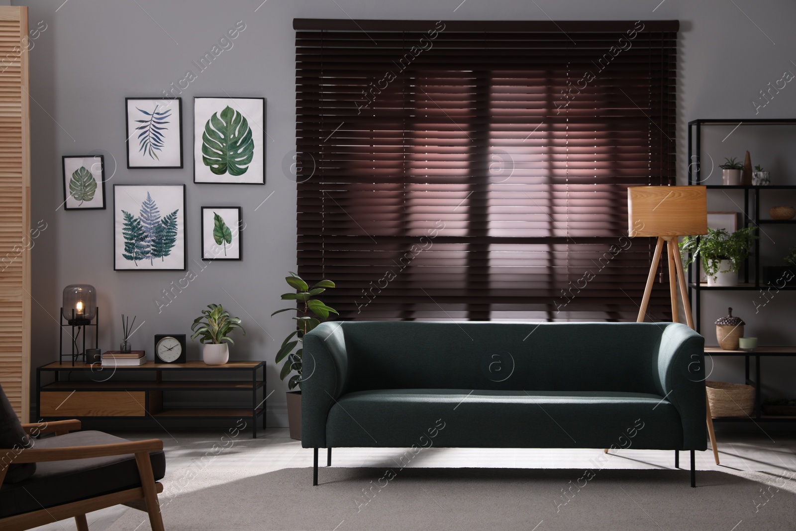 Photo of Stylish living room interior with comfortable sofa and green houseplants