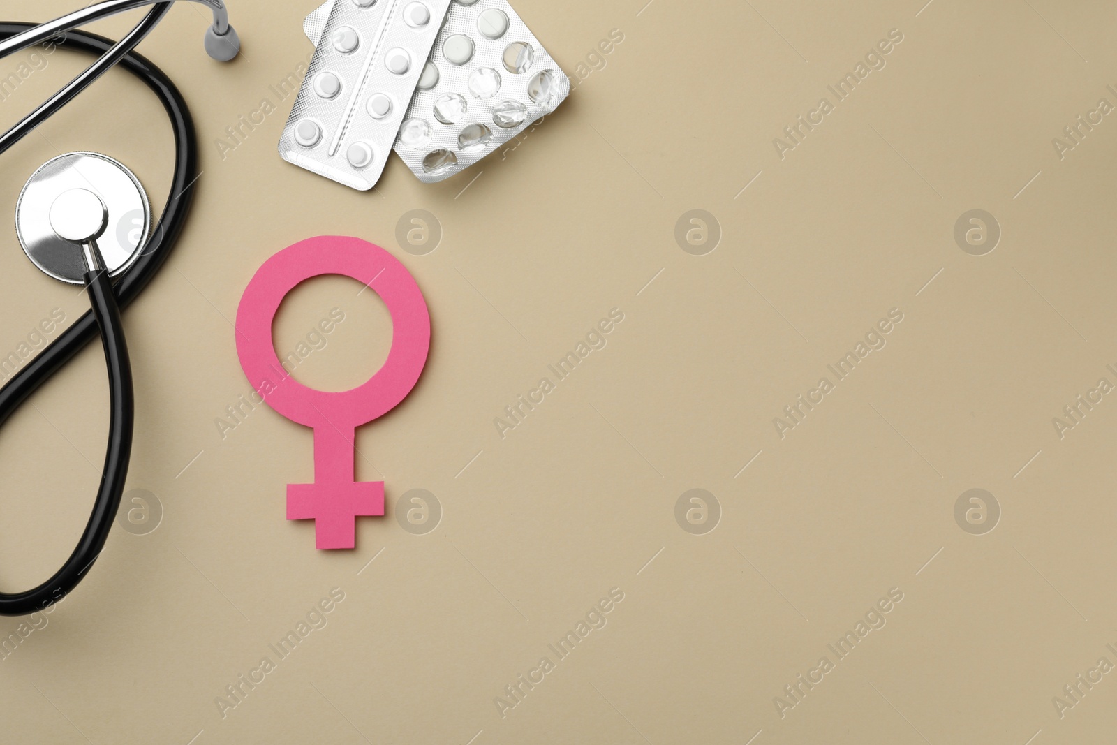 Photo of Female gender sign, stethoscope and pills on beige background, flat lay with space for text. Women's health concept