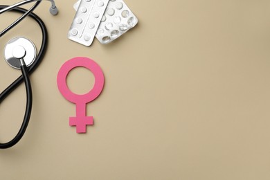 Photo of Female gender sign, stethoscope and pills on beige background, flat lay with space for text. Women's health concept