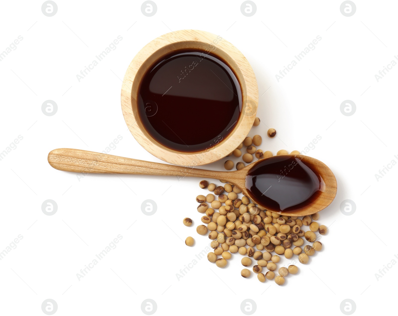 Photo of Tasty soy sauce in bowl, soybeans and spoon isolated on white, top view