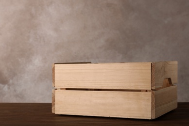 Photo of Wooden crate on table against color background. Space for text