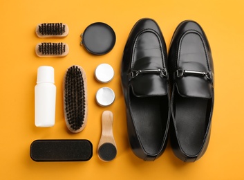 Flat lay composition with shoe care accessories and footwear on yellow background